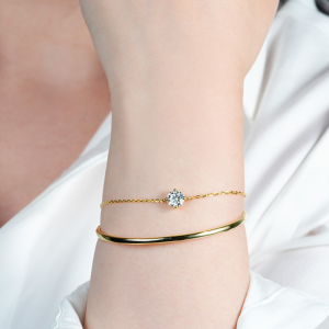 Goudkleurige armband met dubbele band en fonkelende ronde moissanite steen – elegant en verfijnd.