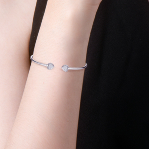 Open armband met glinsterende hartvormige uiteinden in zilverkleur – stijlvol en vrouwelijk.