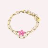 Goudkleurige stainless steel armband met roze bloem en verstelbare schakels, elegante damesarmband met bloemdetail.