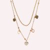 Goudkleurige stainless steel dubbele ketting met verschillende hartjesbedels, waaronder een pavé hartje en open hartje.