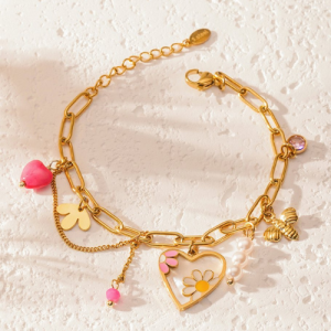 Elegante gouden armband met kleurrijke bedels in de vorm van een hartje, bloem, bij en parels – een speelse accessoire voor elke outfit.